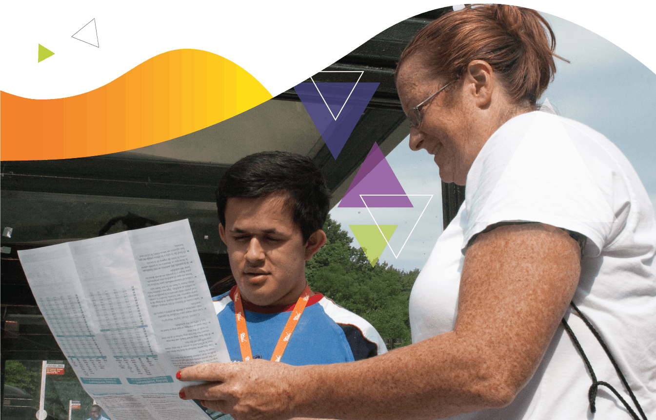 A female travel trainer shows a young man a transit system map. Working with PRTC, MTM created a sustainable travel training program that focuses on train the trainer training opportunities.