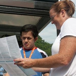 A female travel trainer shows a young man a transit system map. Working with PRTC, MTM created a sustainable travel training program that focuses on train the trainer training opportunities.