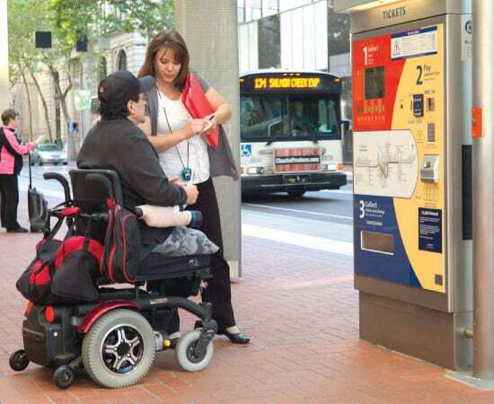 An MTM Transit assessor shows a man who utilizes a wheelchair how to use the TriMet bus. MTM Transit assessments help ensure LIFT paratransit eligibility for TriMet.