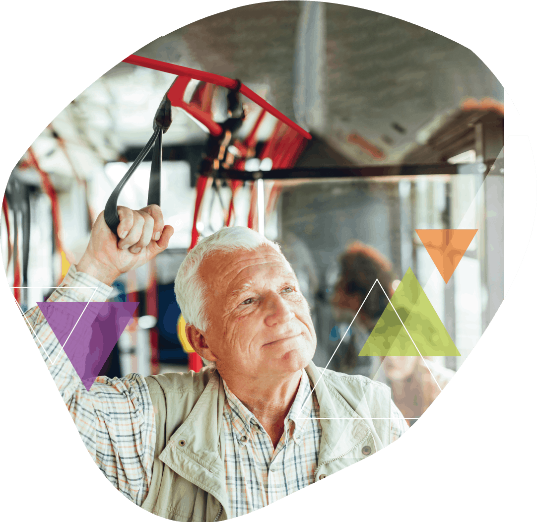 An older man holds the hand hold while riding the bus. MTM Transit solves our clients' toughest transit challenges, because every trip is important to us.