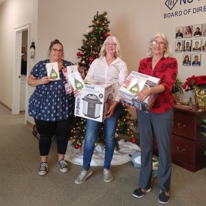 Safety Transportation’s Irene Handley, MTM Transit’s General Manager Kelly Brooks, and NU HOPE Executive Director Debbie Slade show off the gifts purchased for NU HOPE clients.