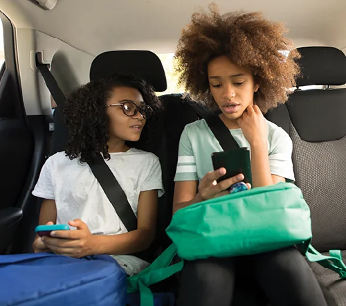 Two students in the back of a car