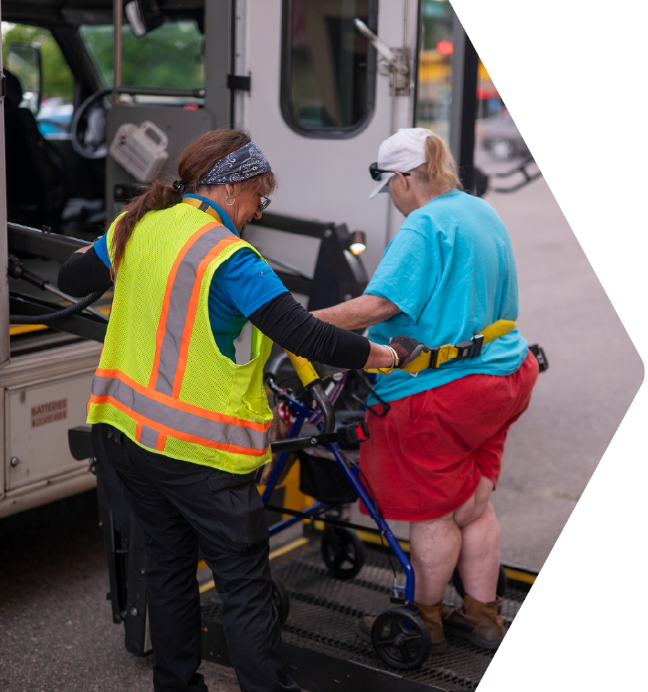 Driver raising passenger up on the bus lift