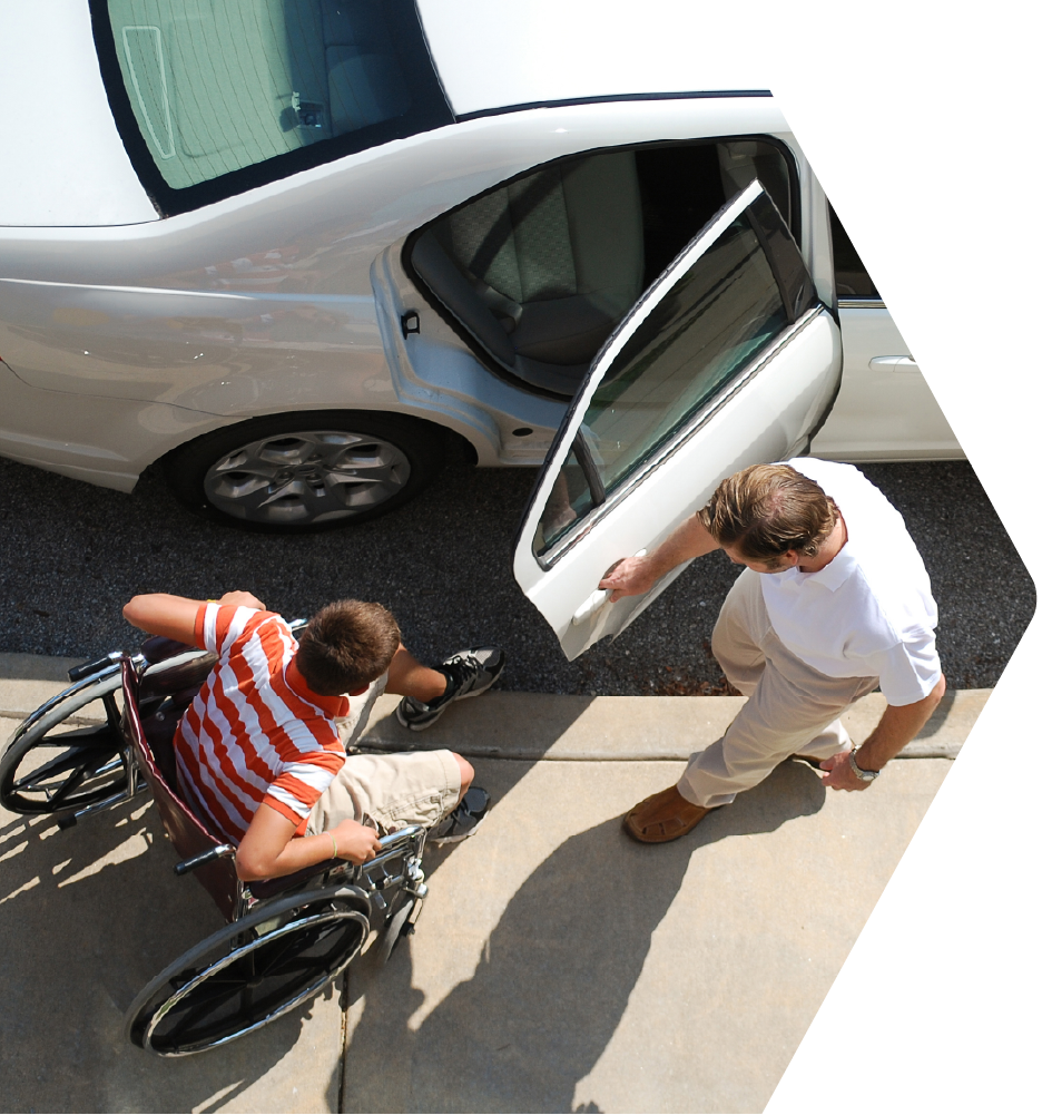 Driver holding car door open for passenger in wheelchair