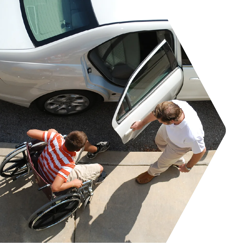 Driver holding car door open for passenger in wheelchair