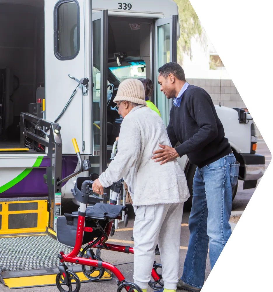 Driver helping a passenger with a walker onto the lift