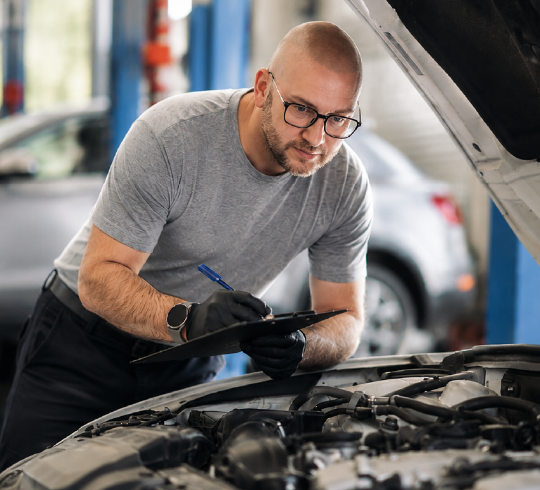 Driver looking under the hood of a vehicle