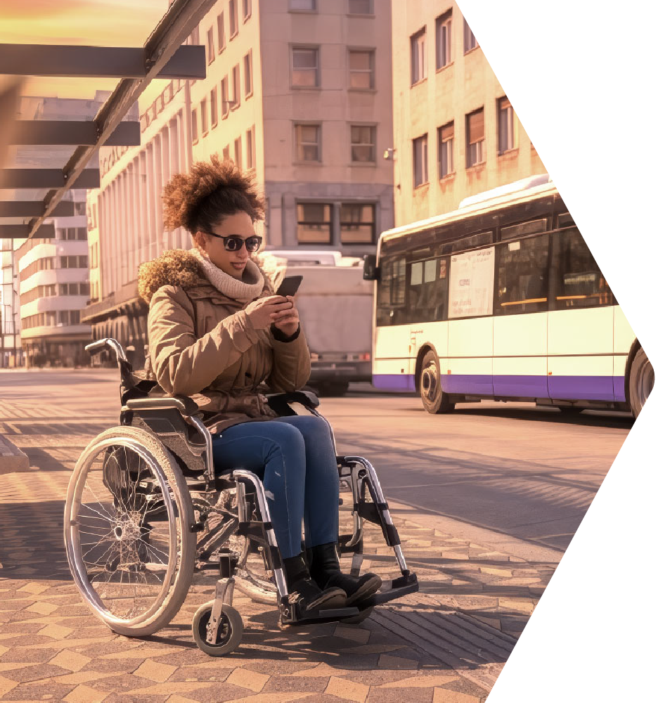 Passenger in a wheelchair waiting at the bus stop, looking at her phone