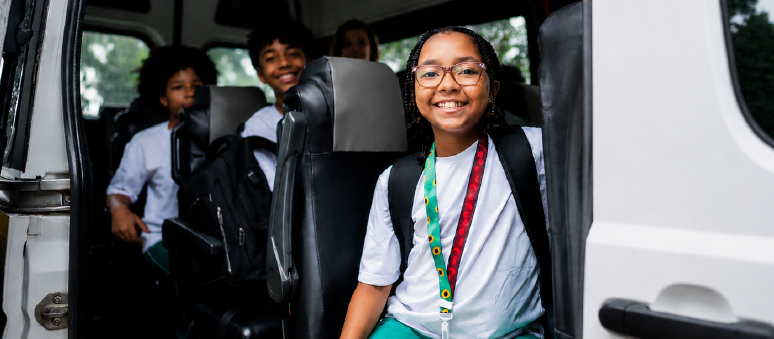 Smiling students in the back of a van
